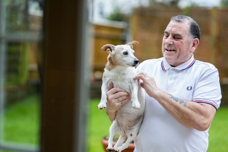 Older man sitting with his dog, a quiet companionship in a senior dog's later years